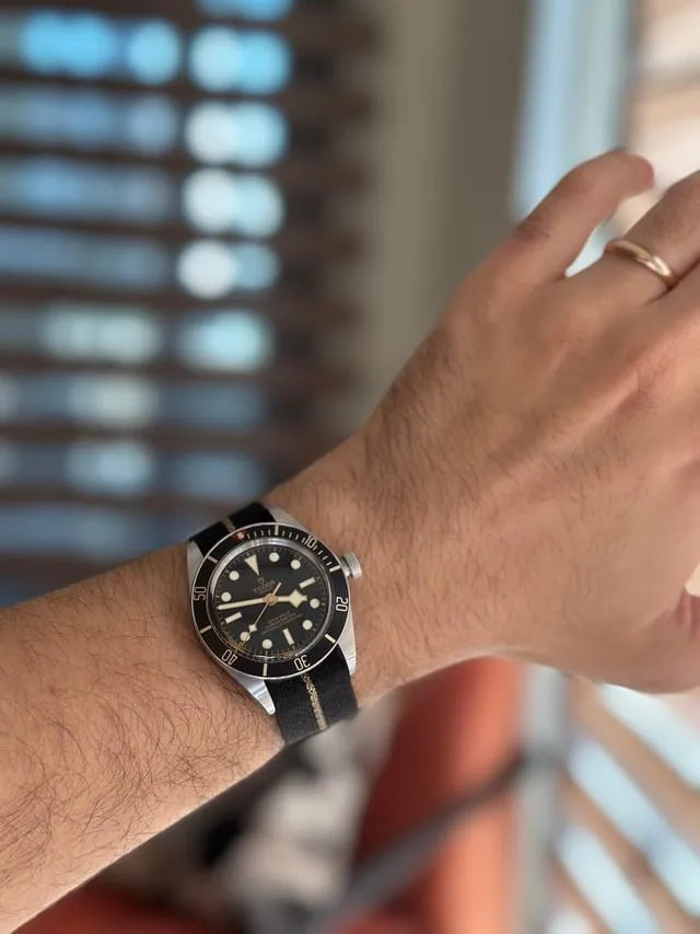 Tudor Black Bay 58 on wrist with fabric NATO strap, bokeh background