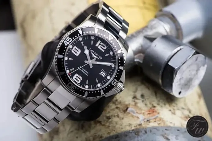 Longines HydroConquest black dial on bracelet, three-quarter shot on industrial surface